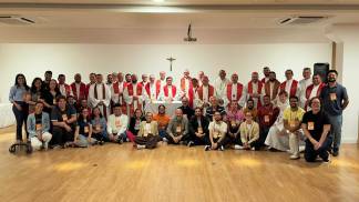 Grupo de pessoas a frente de uma parede branca, posicionados para a foto. Esse grupo representa a Comissão para a Juventude