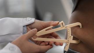 Médico medindo o percentual de gordura de paciente