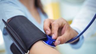 Doutor conferindo a pressão da paciente