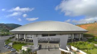 Imagem aérea do Centro de Eventos do Santuário Nacional, com uma imagem do Padre Vítor Coelho segurando Noss Senhora