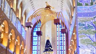 Trono de Nossa Senhora com papéis brilhantes caindo atrás 