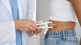 Médico medindo a gordura abdominal da paciente