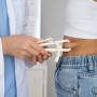 Médico medindo a gordura abdominal da paciente