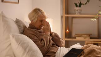 mulher rezando sentada na cama 