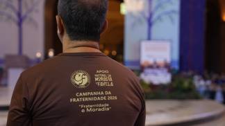 homem com a camisa da campanha da fraternidade 2026 missa