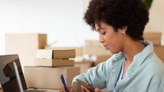 Mulher anotando informações antes de comprar um produto/serviço