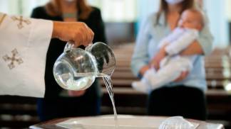 padre enchendo a pia batismal para um batizado