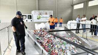 Colaboradores colocando materiais reciclaveis na esteira da Usina de Reciclagem 