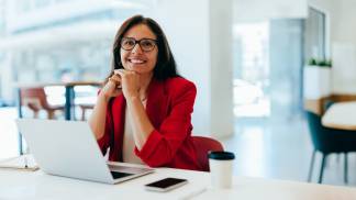 mulher sorrindo na mesa de trabalho