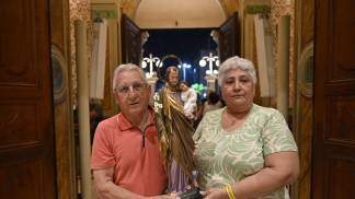 casal segura a imagem de são josé para adentrar no altar durante novena de são josé 2026