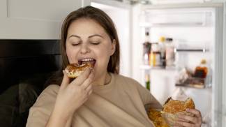 Mulher comendo por compulsão alimentar