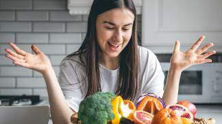 Mulher feliz com os alimentos para uma refeição saudável