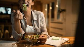 Mulher quebrando jejum comendo uma salada