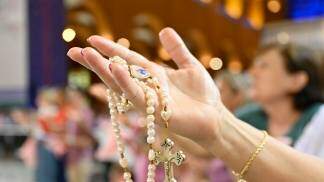 Mão estendida com terço