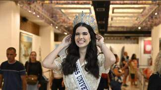 miss brasil maria gabriela lacerda com as mãos próximas a coroa em frente a sala das promessas