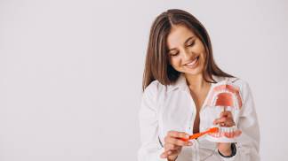 Mulher fazendo uma simulação de como escovar os dentes e manter a saúde bucal