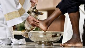 padre lavando os pés de um homem na quinta-feira santa