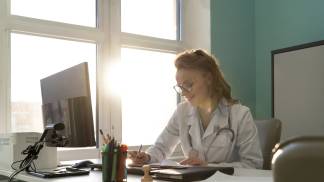 Médica em sua sala pronta para atendimento