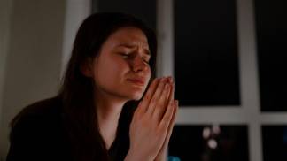 Mulher rezando e chorando