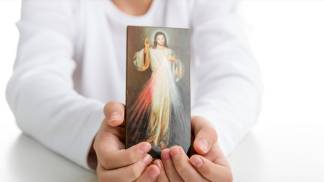 pessoa segura quadrinho de jesus misericordioso