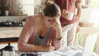 Mulher preocupada calculando suas dívidas