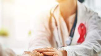 Médico segurando as mãos de paciente