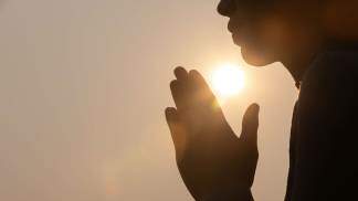 Pessoa em oração pessoal Tinnakorn Adobe Stock_compressed