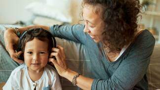 mãe e filho compartilhando um fone de ouvido para ouvir música