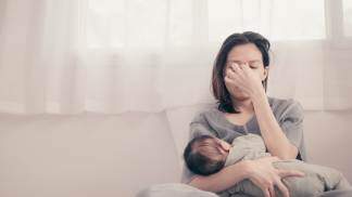 mãe cansada com bebê no colo