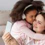 mãe e filha abraçadas ouvindo música com fones de ouvido