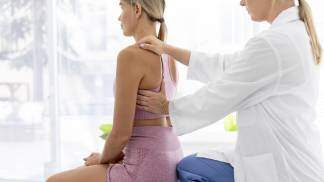 Mulher no consultório médico avaliando a coluna