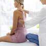 Mulher no consultório médico avaliando a coluna
