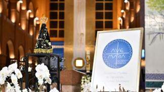 Imagem de Nossa Senhora Aparecida no Altar Central do Santuário Nacional, ao lado o logo da Academia Marial