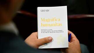 sacertote segura nas mãos um exemplar da encíclica magnifica humanitas