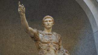 estátua de mármore representando o antigo imperador romano Augusto fazendo uma saudação. AlexanderRuszczynski Adobe Stock