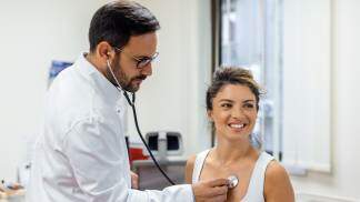 Médico examinando o coração da paciente