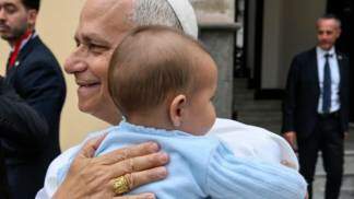 papa leao xiv segura bebê no colo na espanha em viagem apostolica