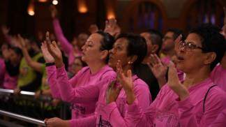 Devotas de Nossa Senhora com as mãos para cima na missa da Corrida Mãe Aparecida