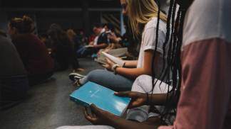 adolescentes lendo a biblia sentados no chão