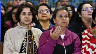 Devota segurando Nossa Senhora Aparecida no Santuáiro Nacional