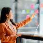 Mulher colando post it no vidro