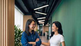 duas mulheres uma lhando para a outra e sorrindo