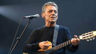 Chico Buarque tocando violão em um palco