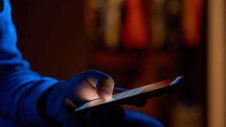 homem segurando o celular no escuro vício tela