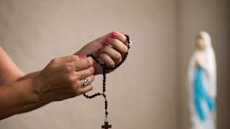 Pessoa com Santo Terço na mão