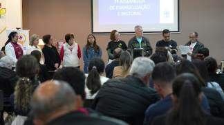 Algumas pessoas em pé a frente apresentando um ponto de vista em uma reunião