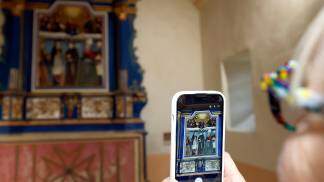 pessoa segurando celular tirando foto da arte sacra na igreja 