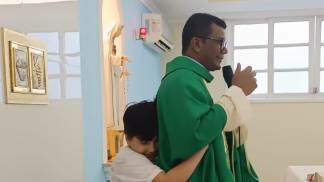 Menino abraçando o padre
