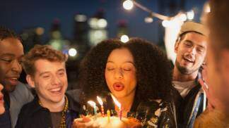 mulher assopra as velas ao fazer aniversário