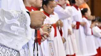 acólitos e coroinhas rezando o terço no altar central